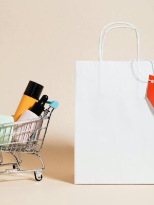 Minimalist image featuring a shopping cart with products and a sale-tagged bag.